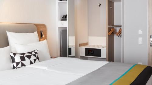 a bedroom with a bed and a small kitchen at Holiday Inn Express Munich - City East by IHG in Munich