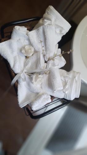a basket filled with white towels and flowers at MiniLoft apartment in Volos
