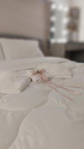 a white bed with two white towels on it at MiniLoft apartment in Volos