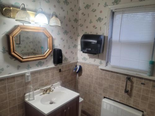 a bathroom with a sink and a mirror at CareHouse Residence in Lawnside