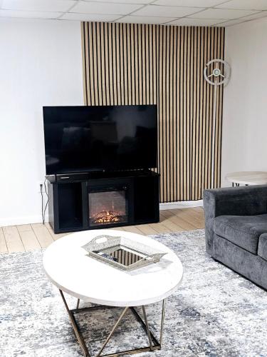 a living room with a fireplace and a tv at Modern Stay with Hot tub in Douglasville