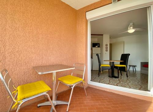 Cette chambre comprend une table, des chaises et un miroir. dans l'établissement Le st françois, à Fréjus