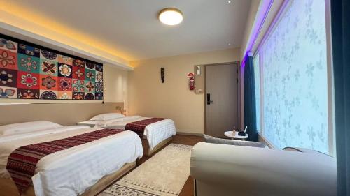 a hotel room with three beds and a large window at Rainbow&Resort in Nadi