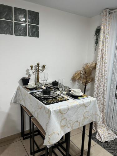 una mesa con mantel blanco y copas de vino en Suite nuptiale équipée, en Cochon Brûlé