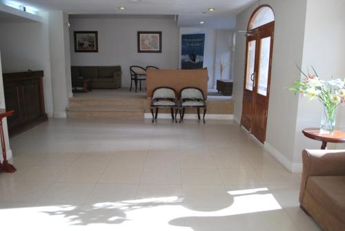 a living room with a couch and a table and chairs at Hotel Gran Madryn in Puerto Madryn