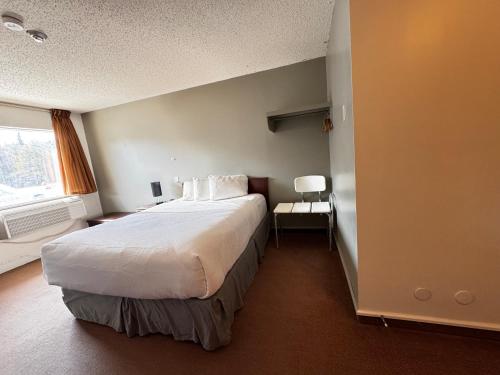 a bedroom with a large bed and a window at Zero - 100 Motor Inn in Heron Bay