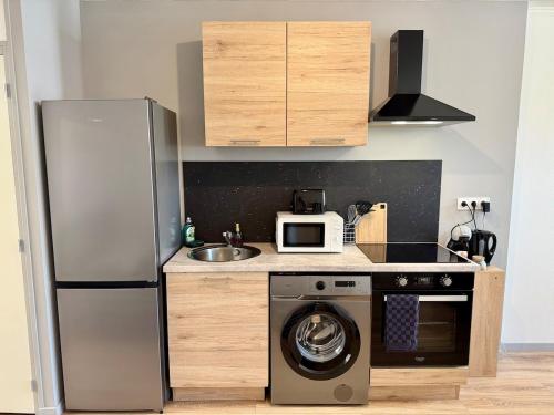 une cuisine avec un réfrigérateur et une machine à laver dans l'établissement Le Coin Jau Wifi Hyper Centre, à Bourges