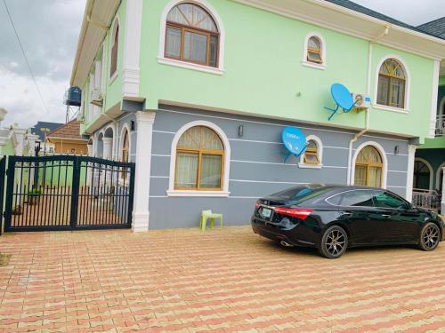 un coche negro estacionado frente a una casa en BOTS Two Bedroom Apartment, en Ilorin