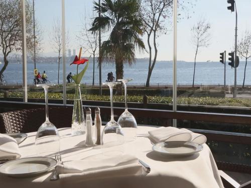 a table with plates and wine glasses on it at Kalyon Hotel Istanbul in Istanbul