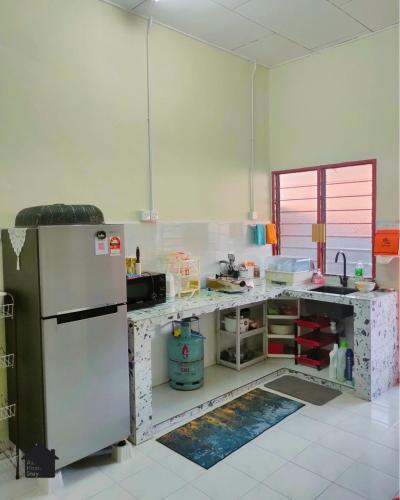 a kitchen with a refrigerator and a counter top at Azo Homestay Parit Raja in Parit Raja