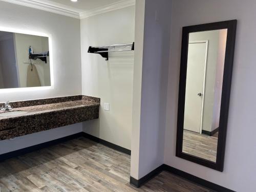 a bathroom with a sink and a mirror at Cloud 9 Inn LAX in Inglewood