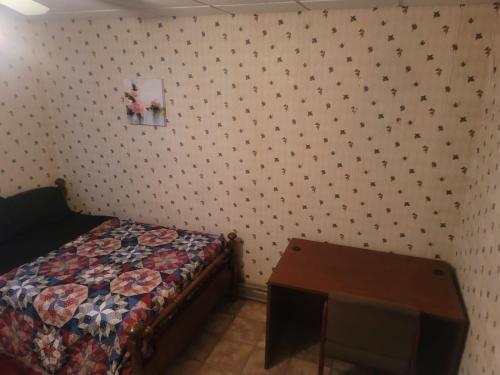 a bedroom with a bed and a wooden table at CareHouse Residence in Lawnside