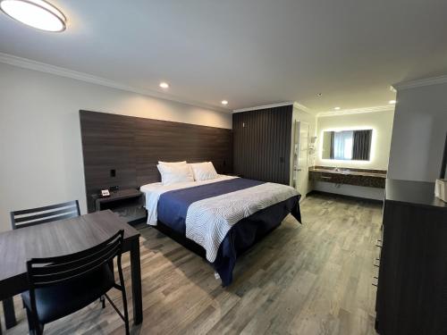 a bedroom with a large bed and a table at Cloud 9 Inn LAX in Inglewood