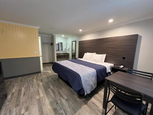 a hotel room with a bed and a table at Cloud 9 Inn LAX in Inglewood