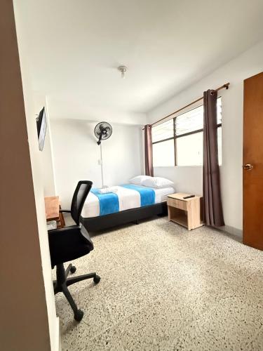 a bedroom with a bed and a desk and a chair at Roomies House By Rincon in Medellín