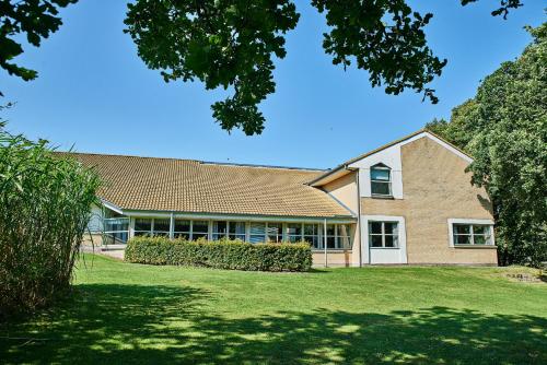 a large brick building with a grass yard at Danhostel Hobro in Hobro