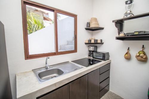 a kitchen with a sink and a window at HAU Holbox, Oceanfront Boutique Hotel in Holbox Island