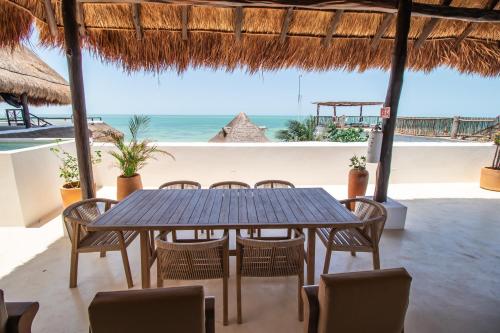 a table and chairs in a restaurant on the beach at HAU Holbox, Oceanfront Boutique Hotel in Holbox Island