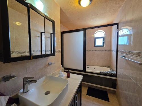 a bathroom with a sink and a bath tub at Ocean view condo with balcony hotel zone Cancun in Cancún