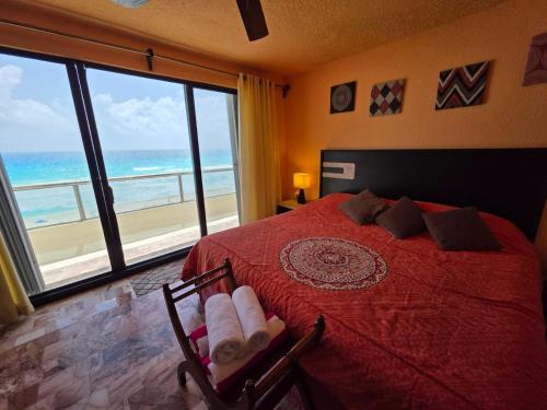 a bedroom with a bed with a view of the ocean at Ocean view condo with balcony hotel zone Cancun in Cancún