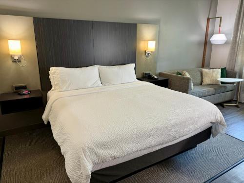 a bedroom with a large white bed and a couch at Holiday Inn Carlsbad/San Diego by IHG in Carlsbad