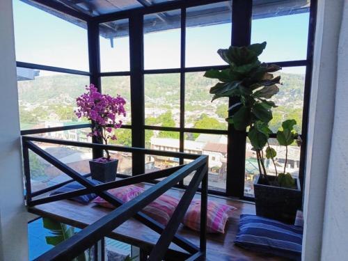a room with a table and some plants and a window at The Bright Apartment in Olongapo in Olongapo