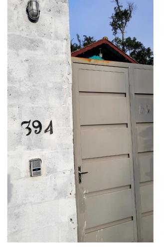 a white garage door next to a white brick wall at Cantinho Dona Cleide in Monte Verde