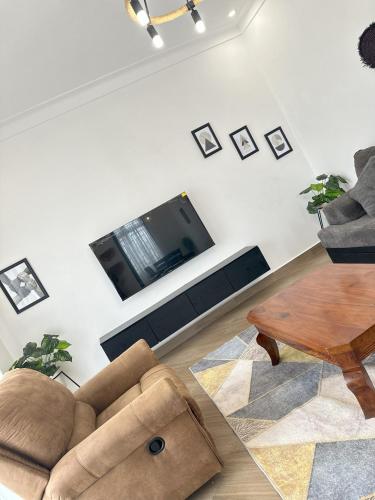 a living room with a couch and a tv at Zaya Residency in Kampala