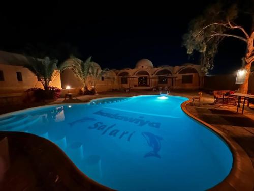 a large swimming pool at night at badawiya farafra hotel in Qasr Al Farafirah