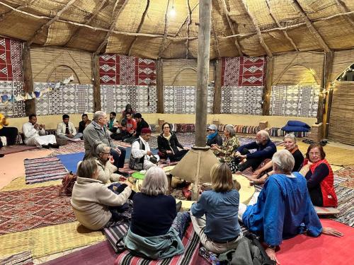 a group of people sitting on the floor in a tent at badawiya farafra hotel in Qasr Al Farafirah
