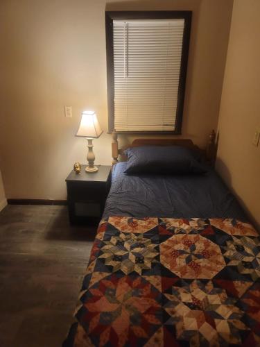 a bedroom with a bed with a quilt on it at CareHouse Residence in Lawnside