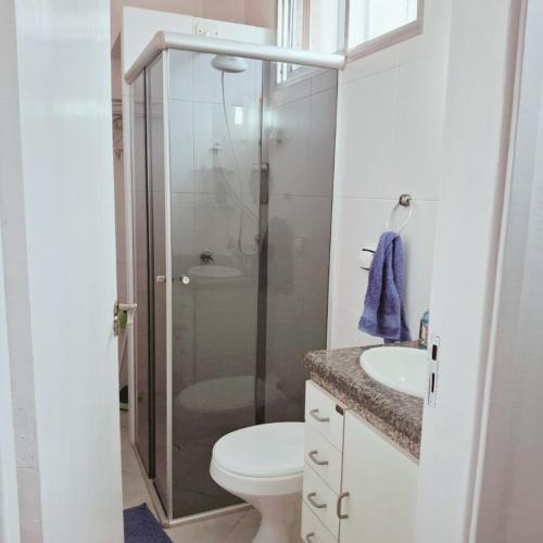 a bathroom with a shower and a toilet and a sink at Apartamento Confortável a 350m da Praia dos Sonhos Itanhaém in Itanhaém