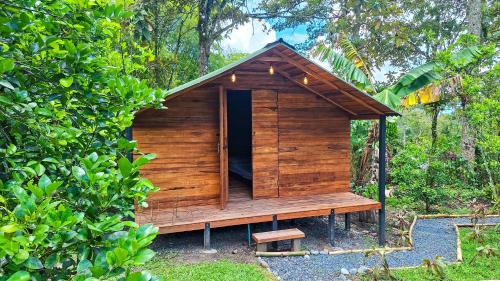 a small wooden house with a bench in a forest at Jardin del Sol Ecoglamping SAS in San José de Suaita