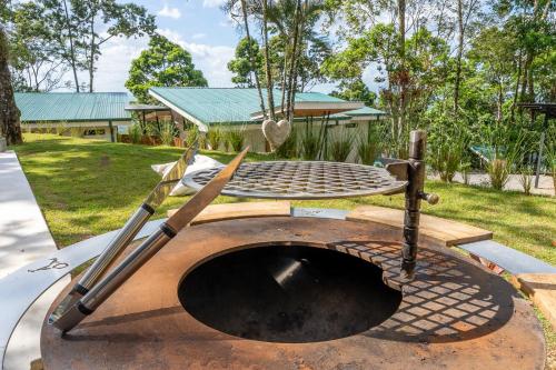 a barbecue grill with two baseball bats and a swing at Pandanus Lodge & Retreats Bungalow Orchidee in San Ramón