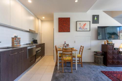 a kitchen and dining room with a table and chairs at Elegant Apartment, Heart of Newtown with Secure Parking in Sydney