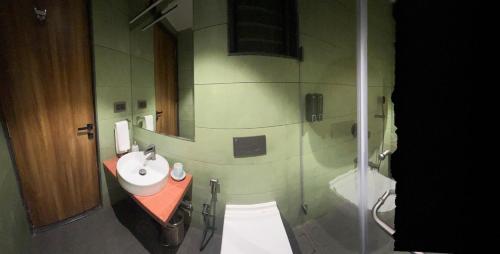 a bathroom with a toilet and a sink and a shower at Ved Villa Netflix, Pool, Chill in Panchgani
