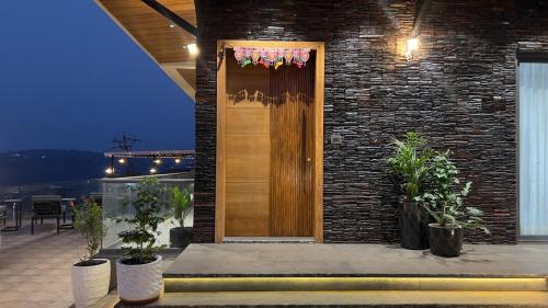 a wooden door on a brick building with potted plants at Ved Villa Netflix, Pool, Chill in Panchgani