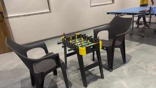 two chairs and a table with a chess set on it at Ved Villa Netflix, Pool, Chill in Panchgani