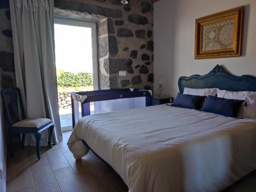 a bedroom with a large bed and a window at Armazéns do Beco - Cacau, Pimenta e Sal in Santa Cruz da Graciosa