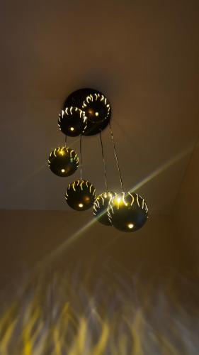 a chandelier with five lights hanging from a ceiling at Ved Villa Netflix, Pool, Chill in Panchgani