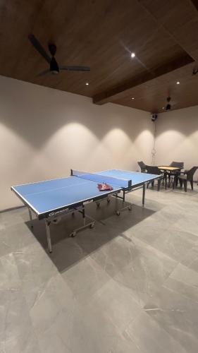 a ping pong table in a room with two tables at Ved Villa Netflix, Pool, Chill in Panchgani