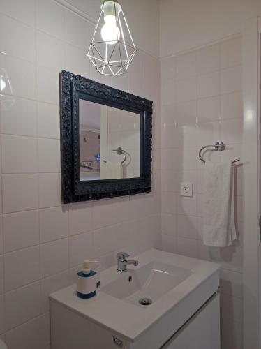 a white bathroom with a sink and a mirror at Armazéns do Beco - Cacau, Pimenta e Sal in Santa Cruz da Graciosa