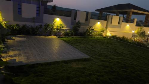 a night view of a lawn in front of a building at Ved Villa Netflix, Pool, Chill in Panchgani