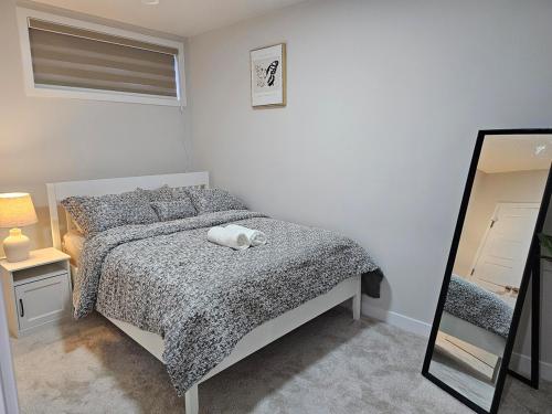 a bedroom with a bed with a cat laying on it at Brand-New Guesthouse-2bedrooms in Calgary