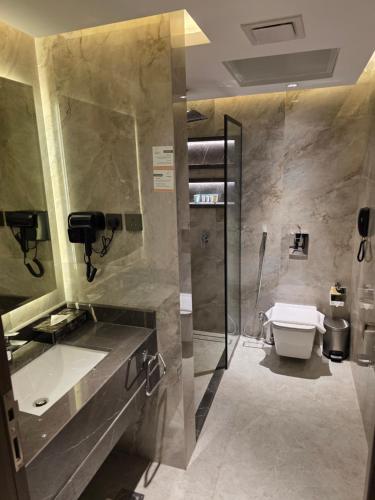 a bathroom with a toilet and a sink and a shower at Sedra Global Hotel, Madinah - فندق سدرة العالمى, المدينة in Al Madinah