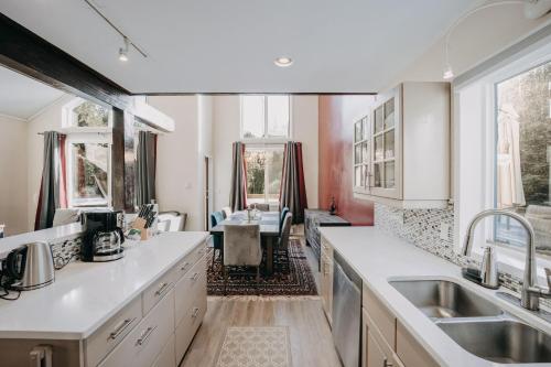 a kitchen with white counter tops and a dining room at 80MBR - Hot Tub - WIFI - BBQ - Wood Stove - Sleeps 7 in Deming