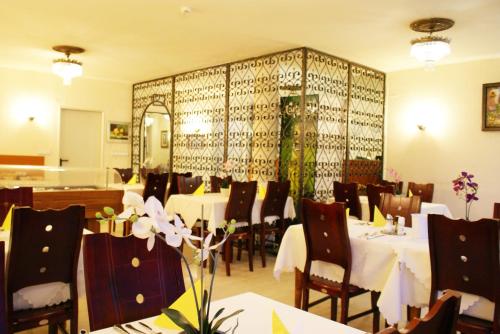 デュッセルドルフにあるバーン - ホテルの白いテーブルと椅子、鏡のあるレストラン