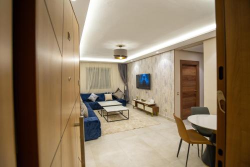 ein Wohnzimmer mit einem blauen Sofa und einem Tisch in der Unterkunft Luxury 2-Bedroom Apartment with Balcony - Heart of Gueliz in Marrakesch