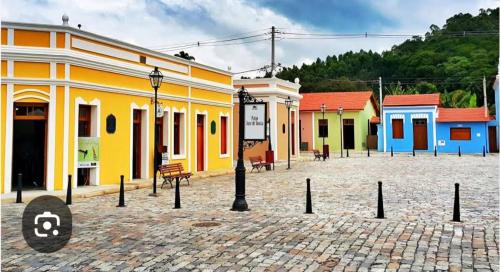a group of colorful buildings in a cobblestone street at Chalé chácara Primavera in Guararema