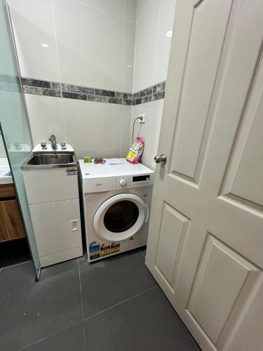 a small bathroom with a sink and a washing machine at Zenith by Proxima Homes in Lautoka